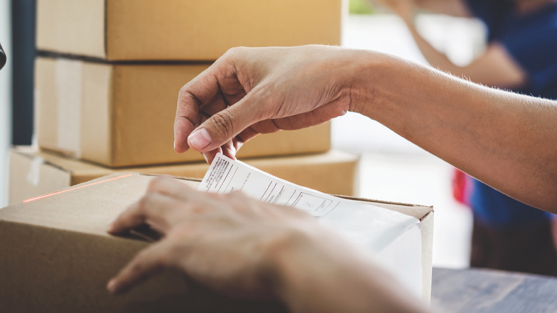 Hands putting a label on a box