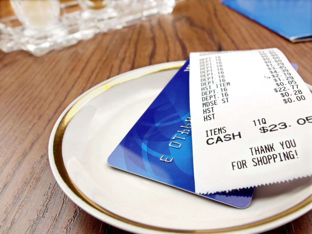 receipt and credit card on a plate