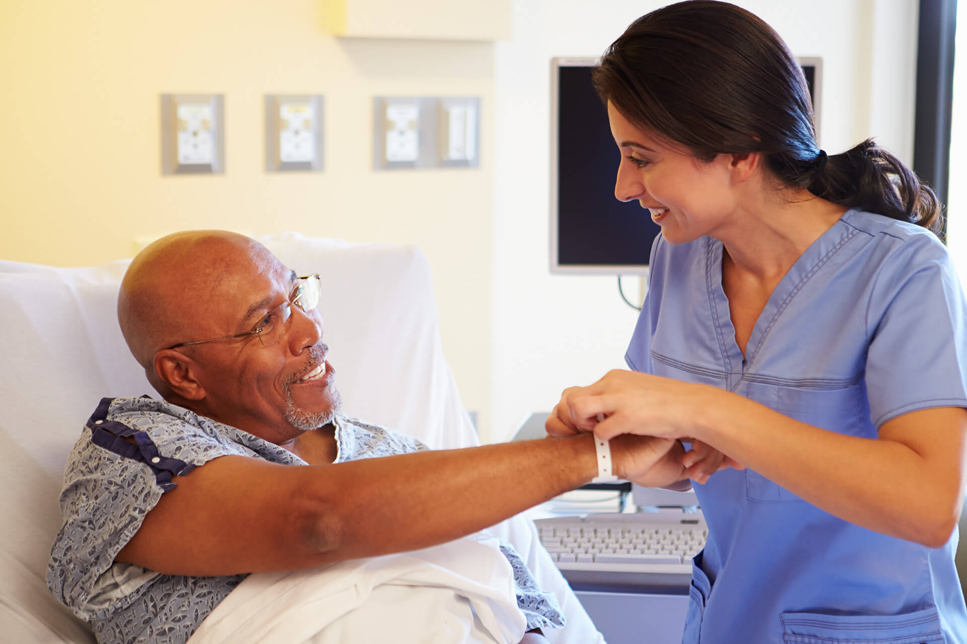 A medical workers adjusts a patient's hospital bracelet